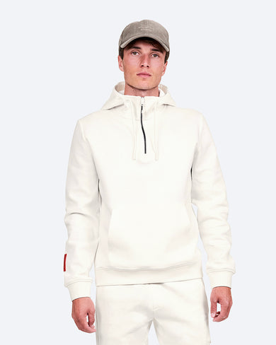 The Mountain Studio H-9 Cotton Tech Hood Half Zip in White Alyssum, on model front, styled with a cap