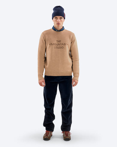 The Mountain Studio K-3 TMS Ski Sweater in Otter, on model front, with beanie