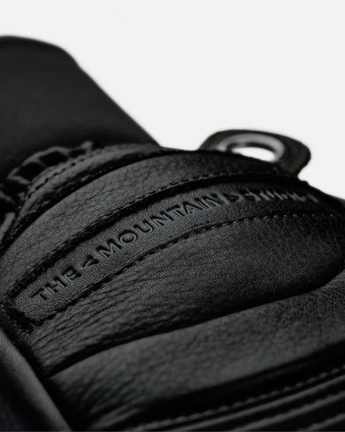 W-29 TMS & HESTRA Leather Mitten, close-up of leather texture and logo stamp