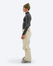 Side view of a person wearing The Mountain Studio Y-3 beige shell ski pants, featuring full-length ventilation zippers, reinforced lower legs, and an ergonomic fit, styled with ski boots and a technical base layer. thumbnail image