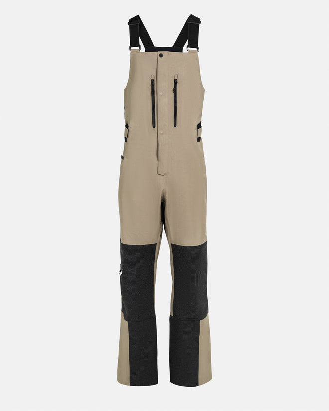 The Mountain Studio Y-7 PRO two-tone beige and black Gore-Tex Pro 3-layer ski bib pants with tall integrated bib, reinforced knees and inner legs, adjustable suspenders, and zippered chest pockets, displayed on a plain background.